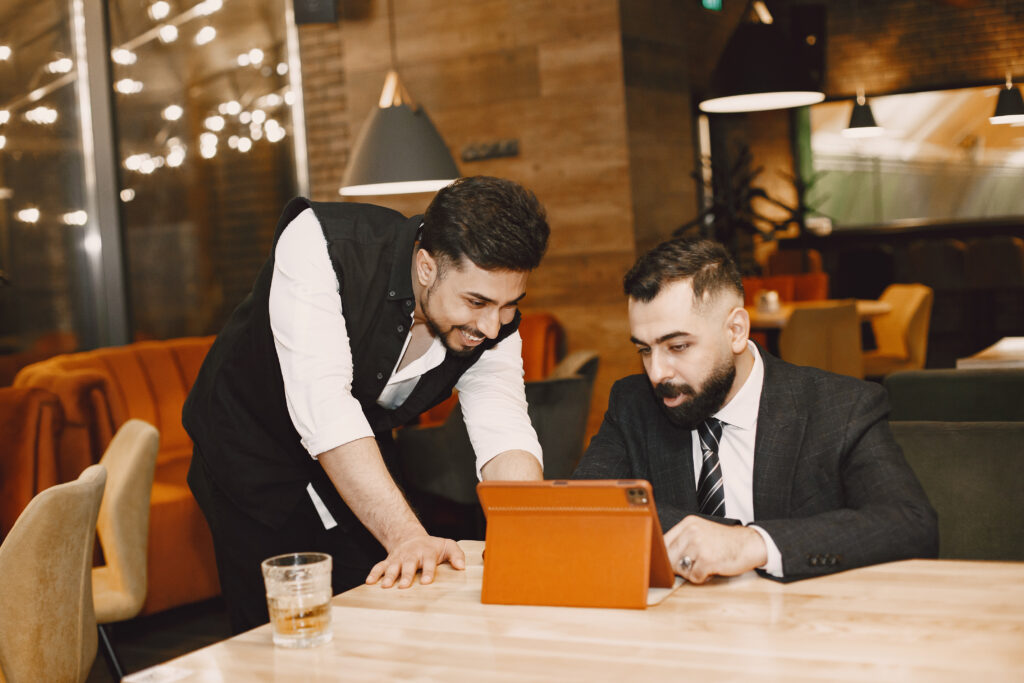 Two stylish businessmen working with laptop together